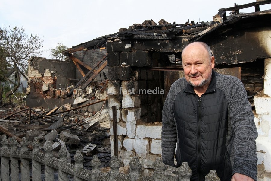 A man stands behind a fence outside a fire-stricken house after a Russian attack on a residential area in Dnipro, Ukraine, October 22, 2026. According to city head Borys Filatov, 11 private houses were damaged in the strike on Thursday morning, and one home burned down completely