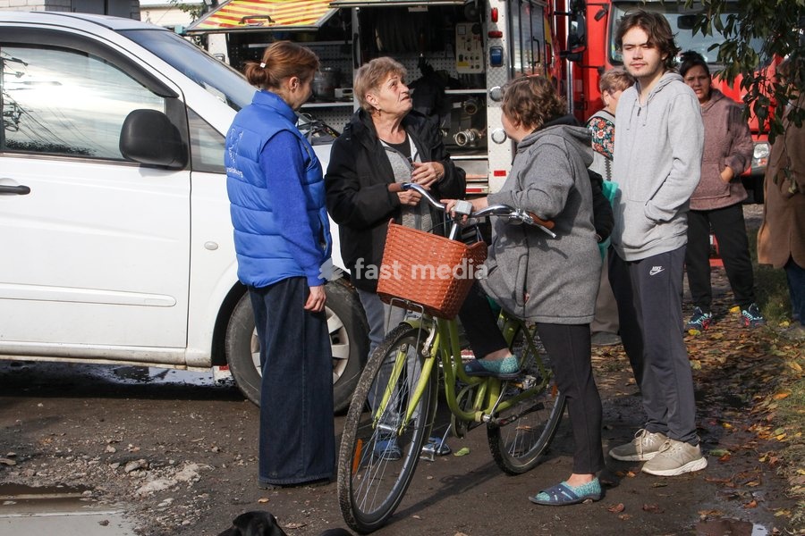 People talk in the street after a Russian attack on a residential area in Dnipro, Ukraine, October 22, 2026. According to city head Borys Filatov, 11 private houses were damaged in the strike on Thursday morning, and one home burned down completely