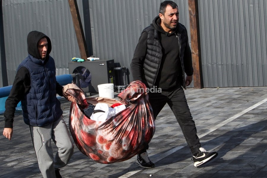 Two men carry salvaged belongings in a blanket cover after a Russian attack on a residential area in Dnipro, Ukraine, October 22, 2026. According to city head Borys Filatov, 11 private houses were damaged in the strike on Thursday morning, and one home burned down completely