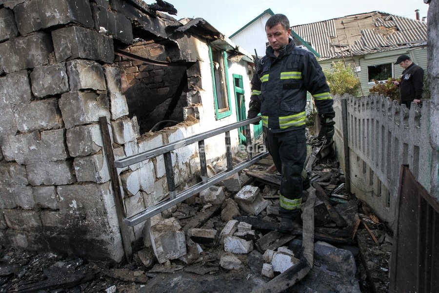 A rescuer carries a ladder during a response effort to a Russian attack on a residential area in Dnipro, Ukraine, October 22, 2026. According to city head Borys Filatov, 11 private houses were damaged in the strike on Thursday morning, and one home burned down completely