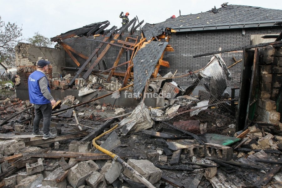 A man watches rescuers work during a response effort to a Russian attack on a residential area in Dnipro, Ukraine, October 22, 2026. According to city head Borys Filatov, 11 private houses were damaged in the strike on Thursday morning, and one home burned down completely