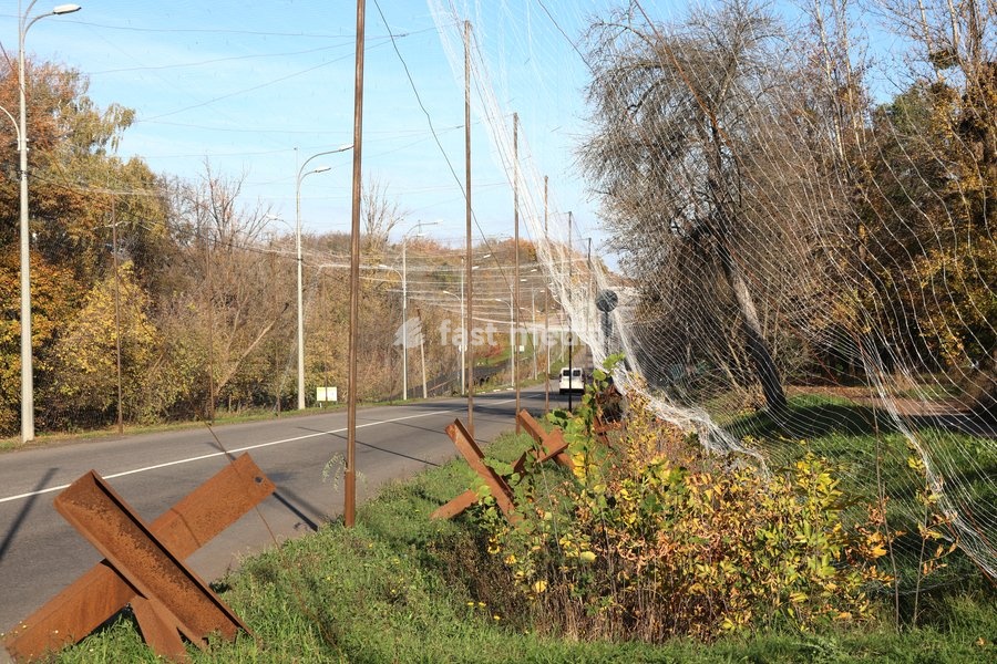 Anti-tank obstacles, known as Czech hedgehogs, run along a road covered with an anti-drone net, Kharkiv, Ukraine, October 24, 2026. Anti-drone nets are being installed to protect civilians and vehicles from Russian UAV strikes