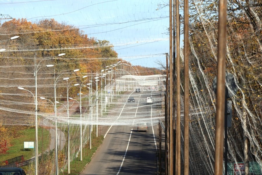 Cars drive along a road covered with an anti-drone net, Kharkiv, Ukraine, October 24, 2026. Anti-drone nets are being installed to protect civilians and vehicles from Russian UAV strikes