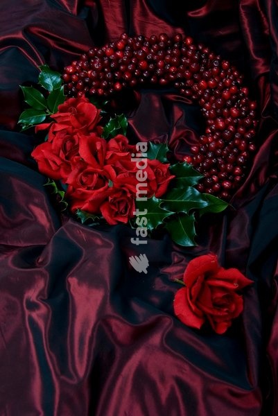 Red Christmas wreath decorated with roses and berries