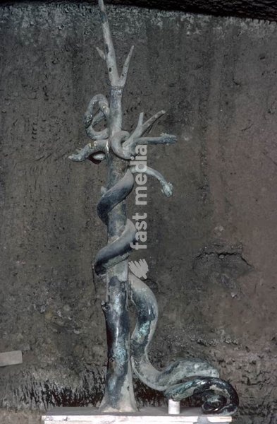 Gulf of Naples, Campania (Italy), Herculaneum, Palaestra (O II), water basin / pool, in the centre a fiveheaded bronze snake that sprayed water. around it the rock–, mud and lava layers that covered Herculaneum after the eruption of Mount Vesuvius. – Detail: five-headed snake centre piece of the…