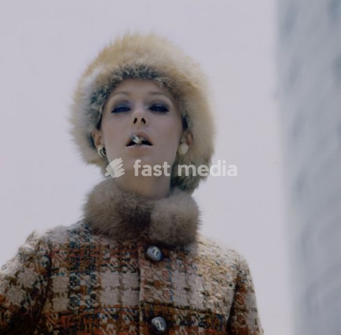 Fashion: Women's fashion / 1960s. Model wearing a fur hat and smoking a cigarette . Photo, undated, 1960s