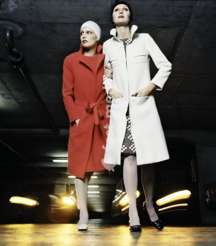 Fashion: Women's fashion, France / Photo, 1960s. Two models in a multi-storey car park, with cars behind them shining their headlights. Photo, Paris, undated