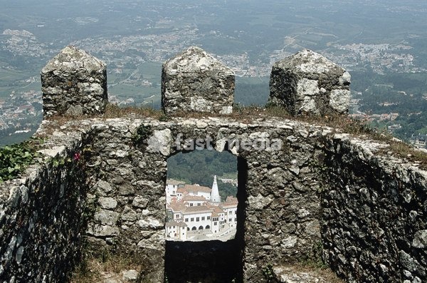 View of National Palace, Palacio Nacional de Sintra, through gap in Mouros Castle wall, Sintra, near Lisbon, Portugal