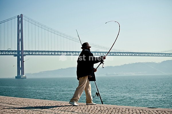 Fisherman in front of 25 de Abril Bridge, 25th of April Bridge, Tagus river, Lisbon, Portugal, Europe