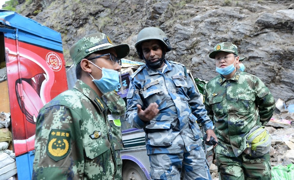(150504) -- NEPAL, May 4, 2015 () -- Chinese rescuers communicate with Nepal rescue personnel (C) after arrived in Nepal on May 4, 2015. At Nepal's request, a rescue team from China's Armed Police Force arrived in the country on Sunday from Zham Town, which lies near the Nepal-China border, to help…