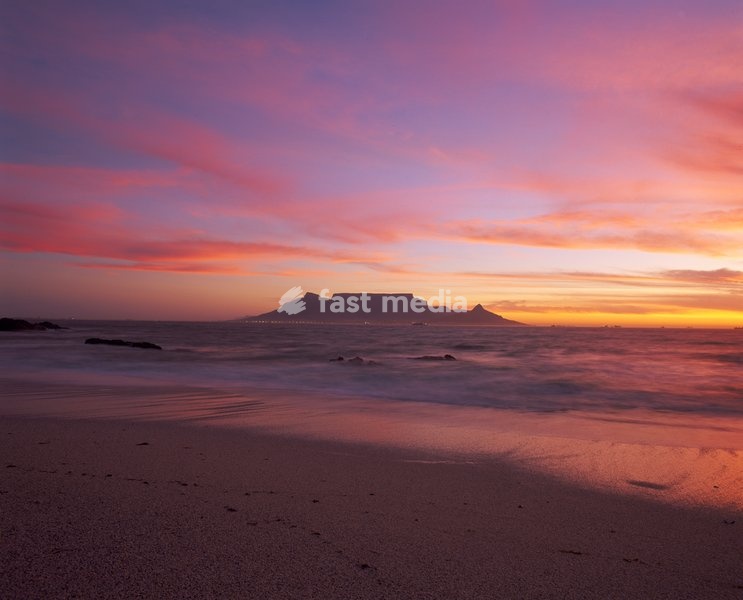 View of Table Mountain at dusk taken from Bloubergstrand shore line dramatic sky