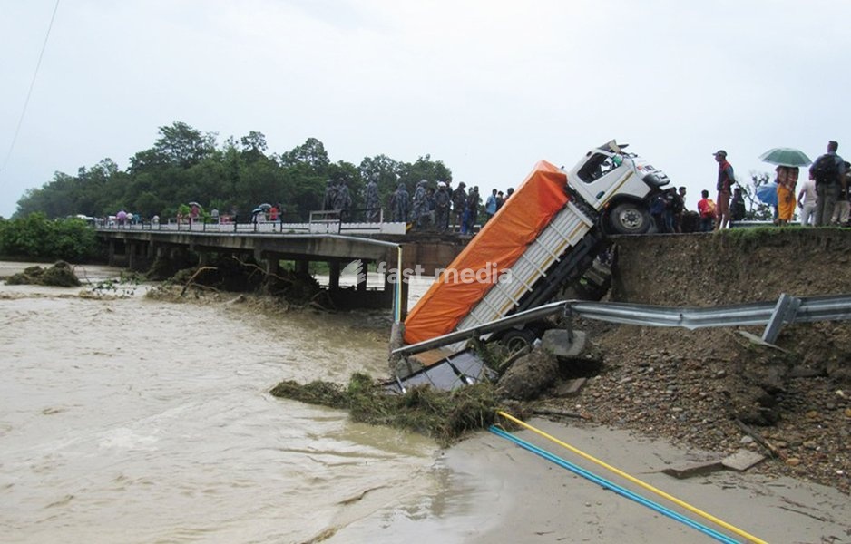(170813) -- MAHOTTARI, Aug. 13, 2017 () -- A truck falls from a collapsed bridge above the Junga river, along the East-West Highway at Maisthan in Mahottari, Nepal, on Aug. 13, 2017. Floods and landslides triggered by incessant rainfall since Friday have killed at least 40 people in Nepal by Sunday…