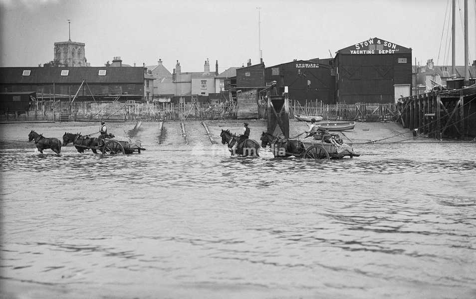 Shoreham harbour, Shoreham-by-Sea, West Sussex, 1905-1925. Two horse-drawn ballast carts in the sea beside the slipway of Stow and Son Yacht Builders
