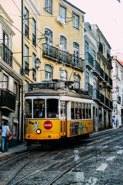 Traditional yellow electric tram in a narrow street in Alfama, Lisbon, Portugal, Europe