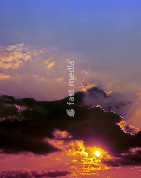 Dramatic sunset against dark clouds and a glowing night sky