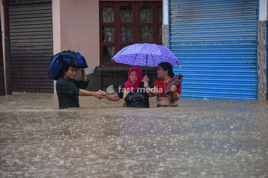 (190712) -- KATHMANDU, July 12, 2019 () -- People tread in the flood in Kathmandu, Nepal, July 12, 2019. Many areas in Nepal were inundated by the swollen Balkhu river following torrential rains since Thursday night