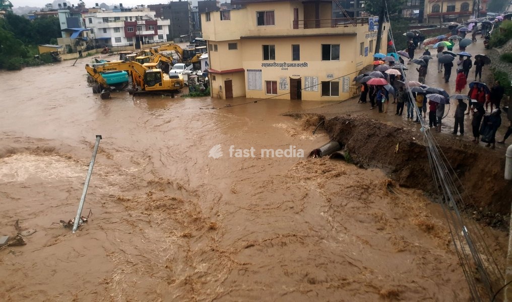 (190712) -- KATHMANDU, July 12, 2019 () -- People watch the swollen Balkhu River that floods the street in Kathmandu, Nepal, July 12, 2019. Many areas in Nepal were inundated by the swollen Balkhu river following torrential rains since Thursday night