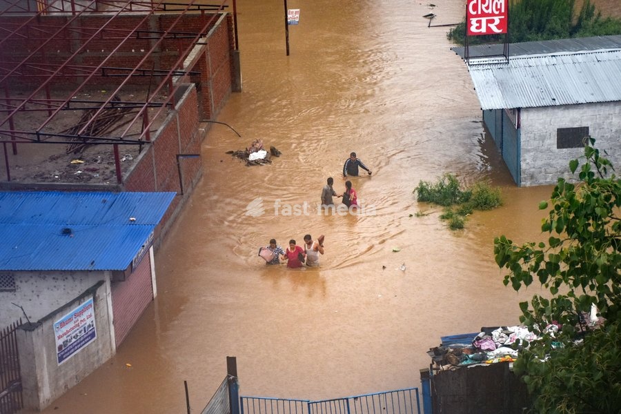 (190712) -- KATHMANDU, July 12, 2019 () -- People tread in the flood in Kathmandu, Nepal, July 12, 2019. Many areas in Nepal were inundated by the swollen Balkhu river following torrential rains since Thursday night