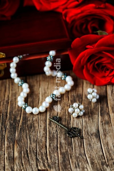 Fresh red roses with pearls on wooden background, copy space