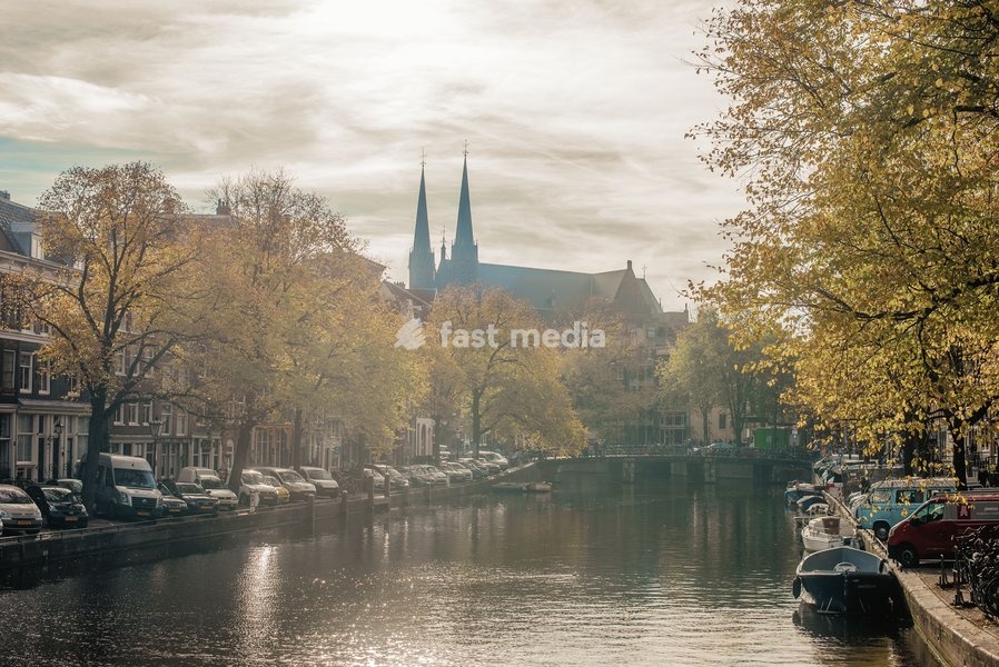 Boats sit moored on a canal in Amsterdam, The Netherlands