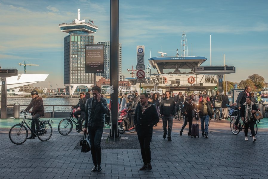 People disembark from a ferry in Amsterdam, The Netherlands