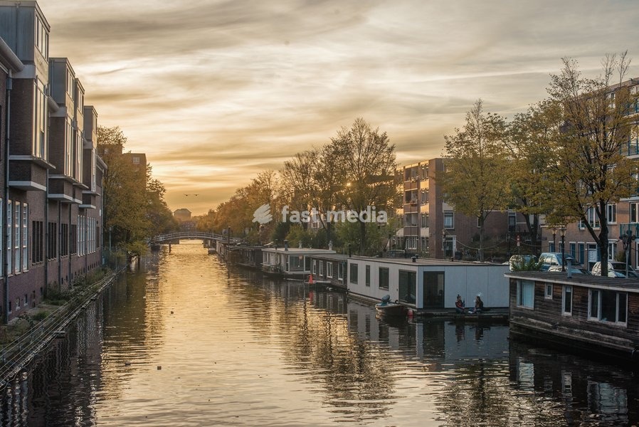 Boats sit moored on a canal in Amsterdam, The Netherlands