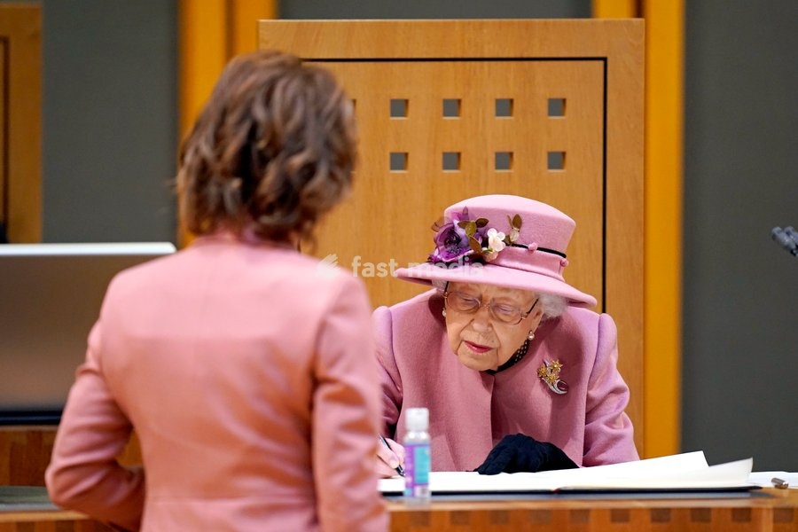 Queen Elizabeth II signs a document inside the Siambr (Chamber) during the ceremonial opening of the Sixth Senedd in Cardiff. Picture date: Thursday October 14, 2021