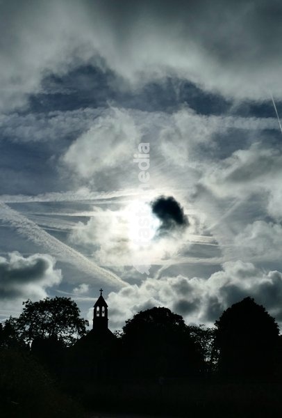 The early mornings sky is a mix of bubbling white clouds and aeroplanes contrails