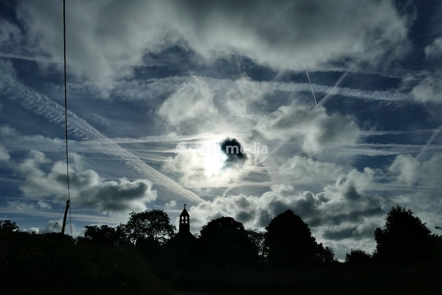 The early mornings sky is a mix of bubbling white clouds and aeroplanes contrails