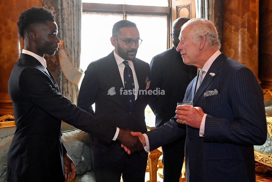 Britain's Prince Charles shakes hands with footballer Bukayo Saka, while he attends a reception celebrating the Commonwealth Diaspora of the United Kingdom, in London, Britain, June 9, 2022. REUTERS/Toby