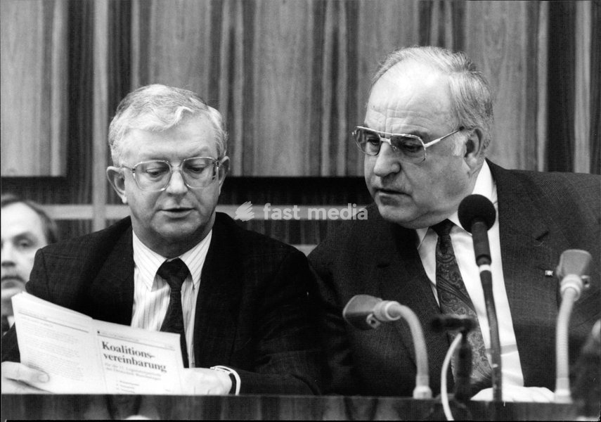 Die Fotografie zeigt den Bundeskanzler Helmut Kohl und den Kanzleramtsminister Rudolf Seiters beim Studium der Koalitionsvereinbarungen in Februar 1991