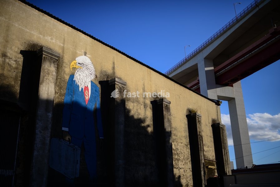 'The Eagle has Landed Part II' graffiti of an eagle in a business suit portrays American capitalism/corporatism and its global impact on cities. LxFactory is an historical industrial complex that houses an array of arty retailers & unique restaurants in Lisbon, Portugal