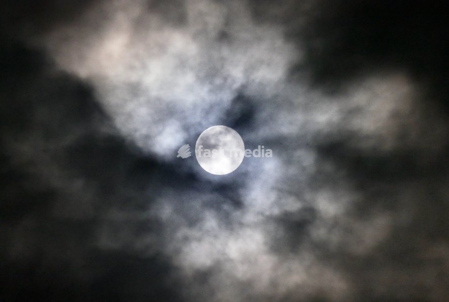 The full Hunters Moon visible at 99.9% surrounded by fast moving thick clouds in the early hours of the morning