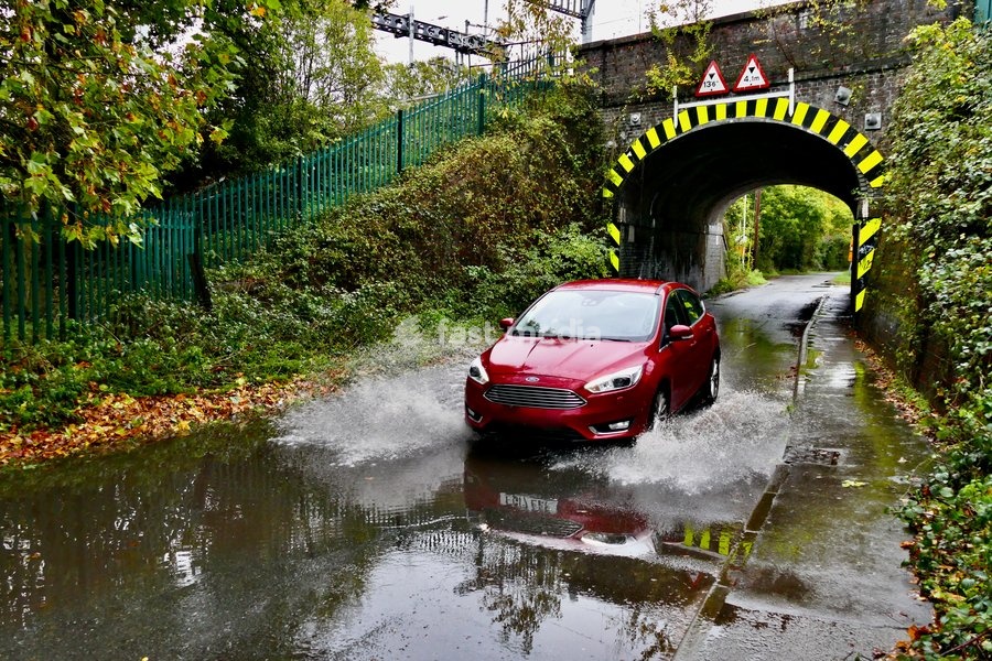 Vehicles make their way down the water logged roads after the heavy rain