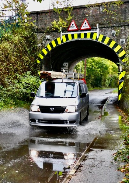 Vehicles make their way down the water logged roads after the heavy rain