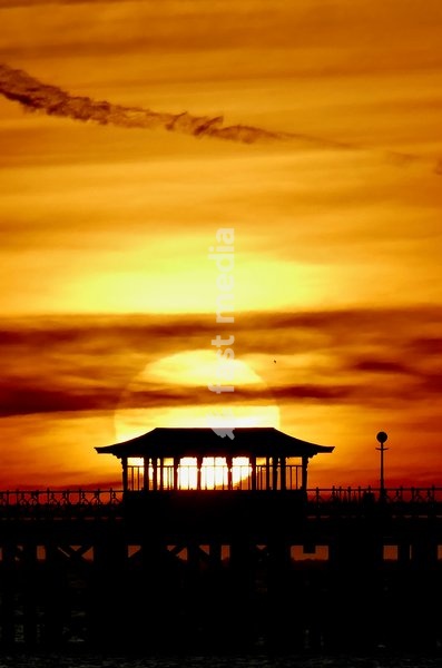 The days sun rises over Swanage Pier