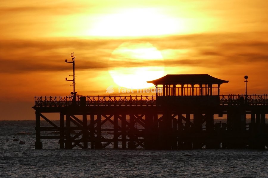 The days sun rises over Swanage Pier
