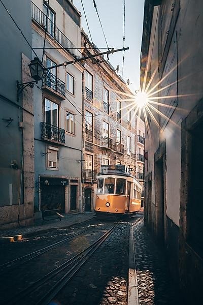 House fronts, narrow streets, alleys and stairs, in a historic old town. beautiful urban place Alfama in the morning with tram, the famous tram 28 in the capital Lisbon, Portugal