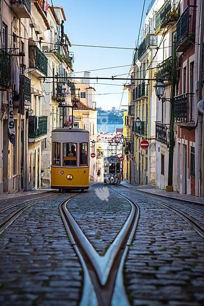 Old houses in narrow alleys and historic streets. Old house fronts in the morning and in the sunshine, Elevador da Bica in the old town of Bairro Alto, Lisbon, Portugal