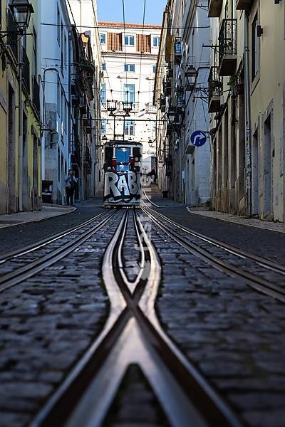 Old houses in narrow alleys and historic streets. Old house fronts in the morning and in the sunshine, Elevador da Bica in the old town of Bairro Alto, Lisbon, Portugal