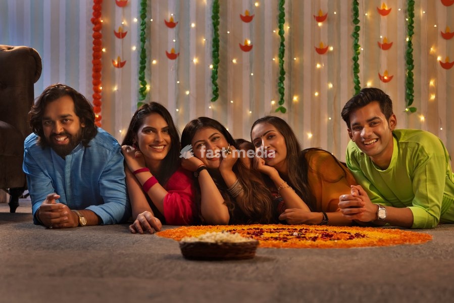 Friends lying together on floor near floral decoration during Diwali celebration