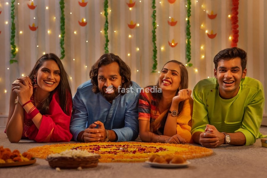 Friends lying together on floor near floral decoration during Diwali celebration