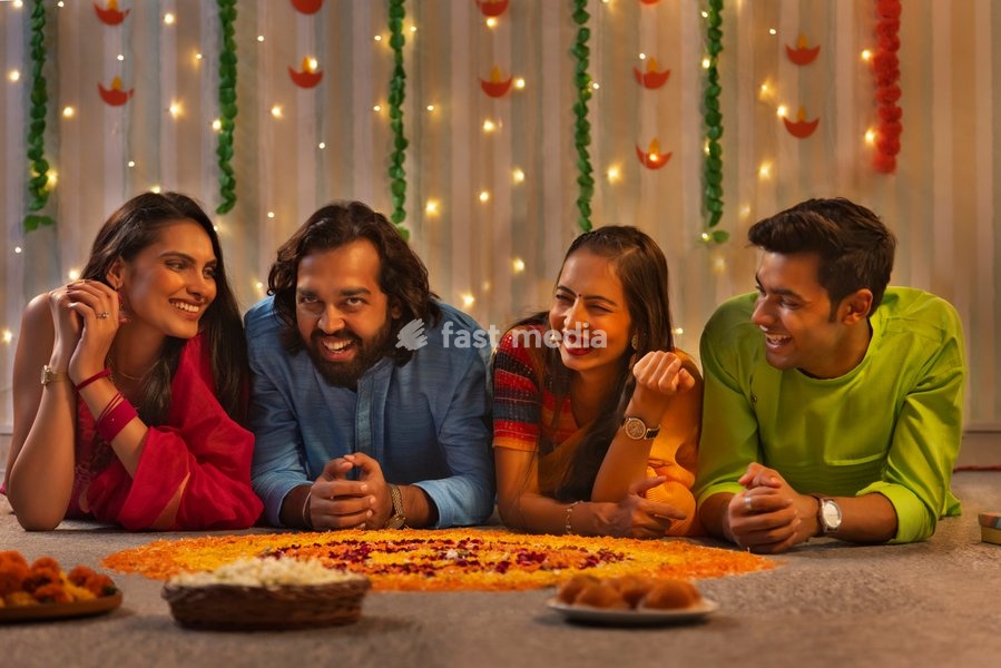 Friends lying together on floor near floral decoration during Diwali celebration