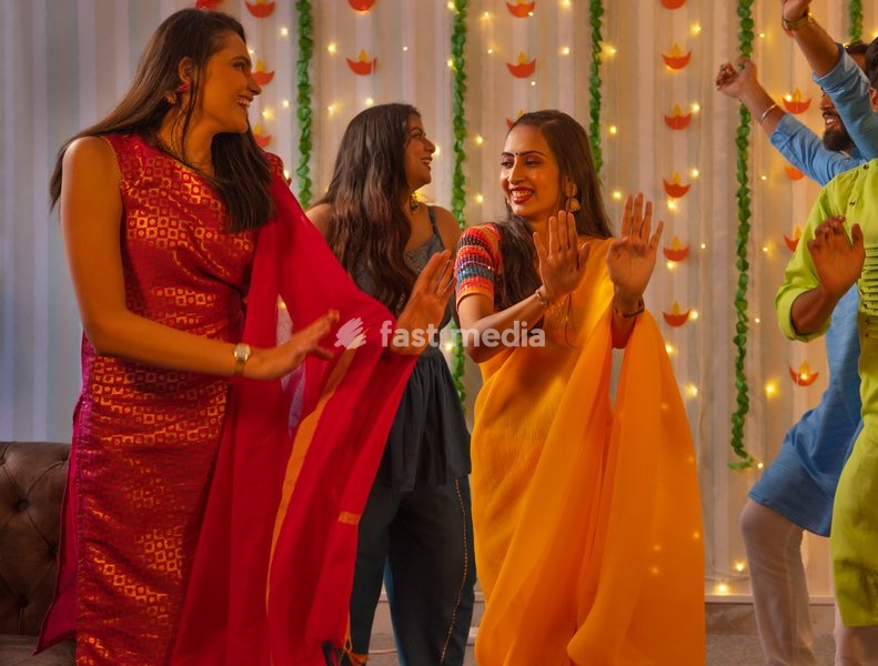 Friends celebrating Diwali together at home by dancing