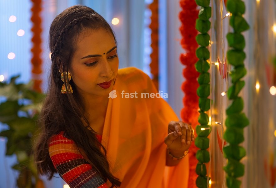 Young woman decorating house on the occasion of Diwali