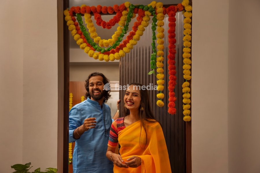 Portrait of smiling man and woman standing at the entrance to welcome their friends