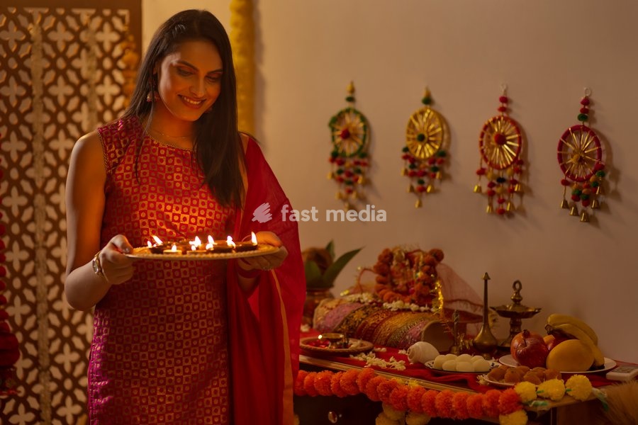Portrait of Indian woman holding a plate of diyas on Diwali