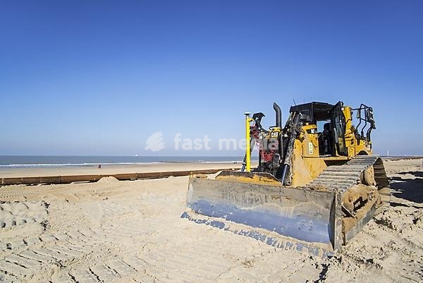 Bulldozer used for sand replenishment, beach nourishment to make wider beaches to reduce storm damage to coastal structures along the Belgian coast