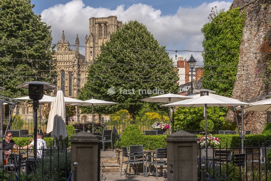 Wells, Somerset, England, UK, Hotel garden dining area with customers enjoying a drink overlooked by Wells Cathedral