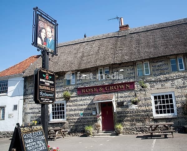 Rose and Crown pub at Tilshead, Wiltshire, England with pub sign painted of Prince William and his wife Kate Middleton